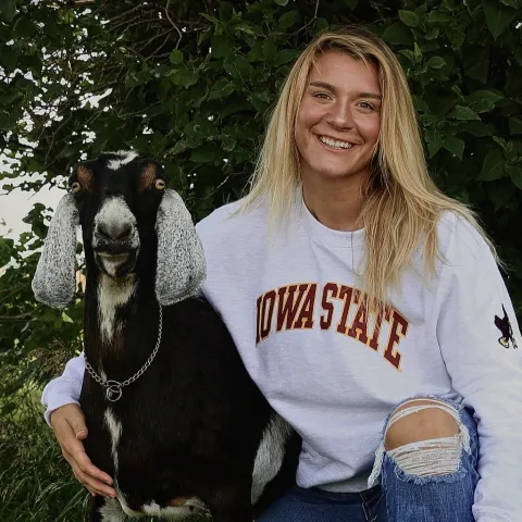 Headshot of Jamy Randol with her arm around a dairy goat